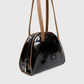 Front view of luxe black patent leather handbag for women