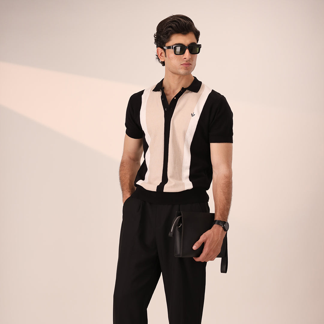 Man holding ATLAS Executive Pouch with business-casual outfit in a modern studio setting.