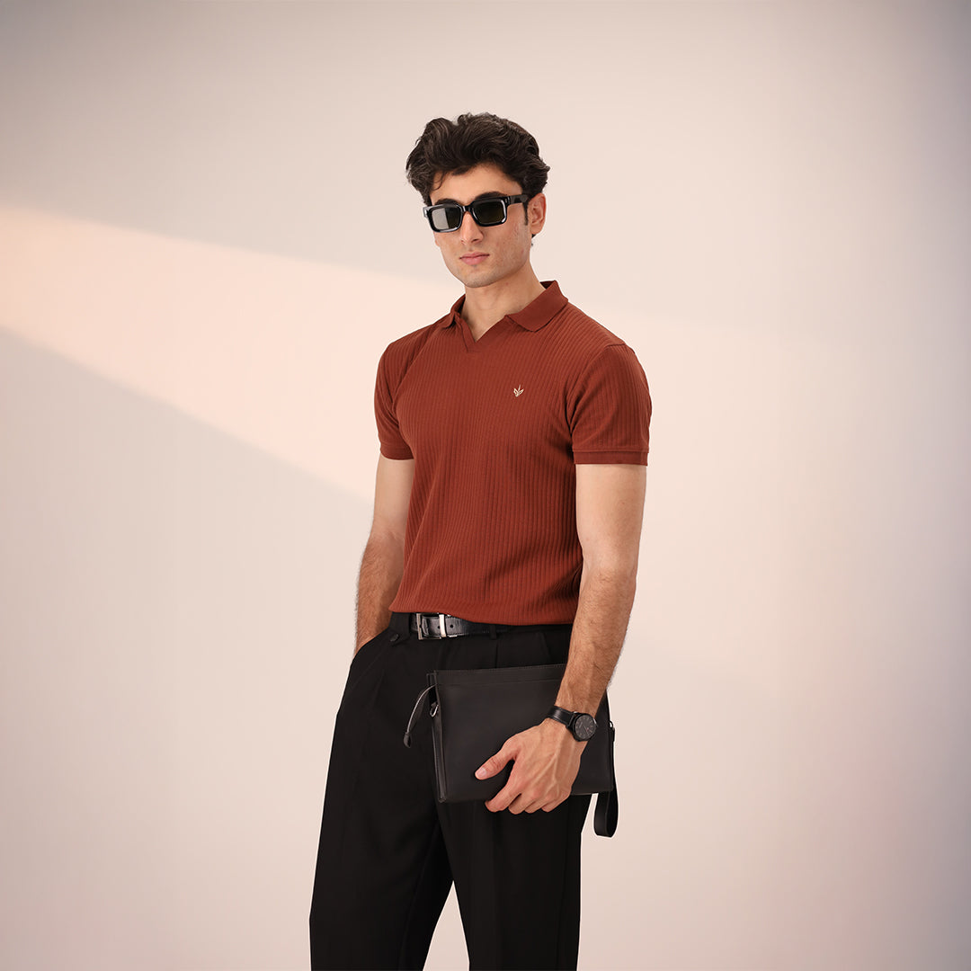 Man holding ATLAS Executive Pouch with business-casual outfit in a modern studio setting.