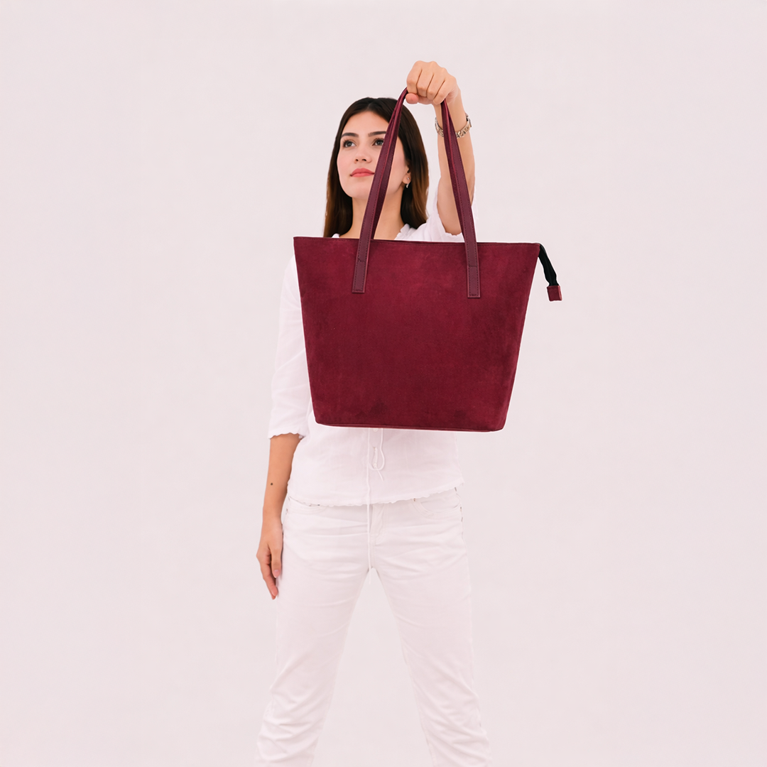Side angle view of burgundy suede tote bag
