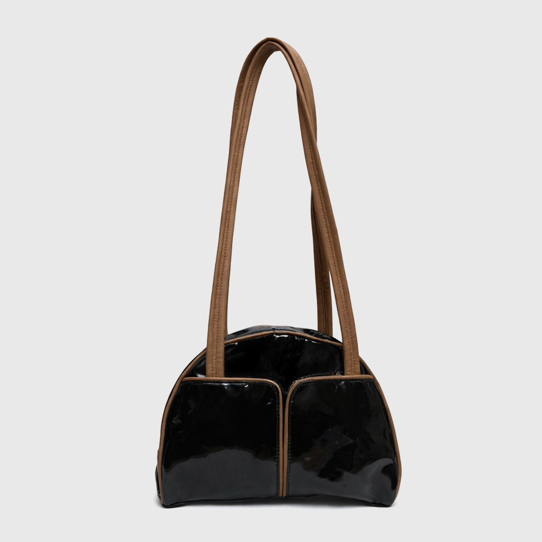 Side angle view of glossy black patent shoulder bag