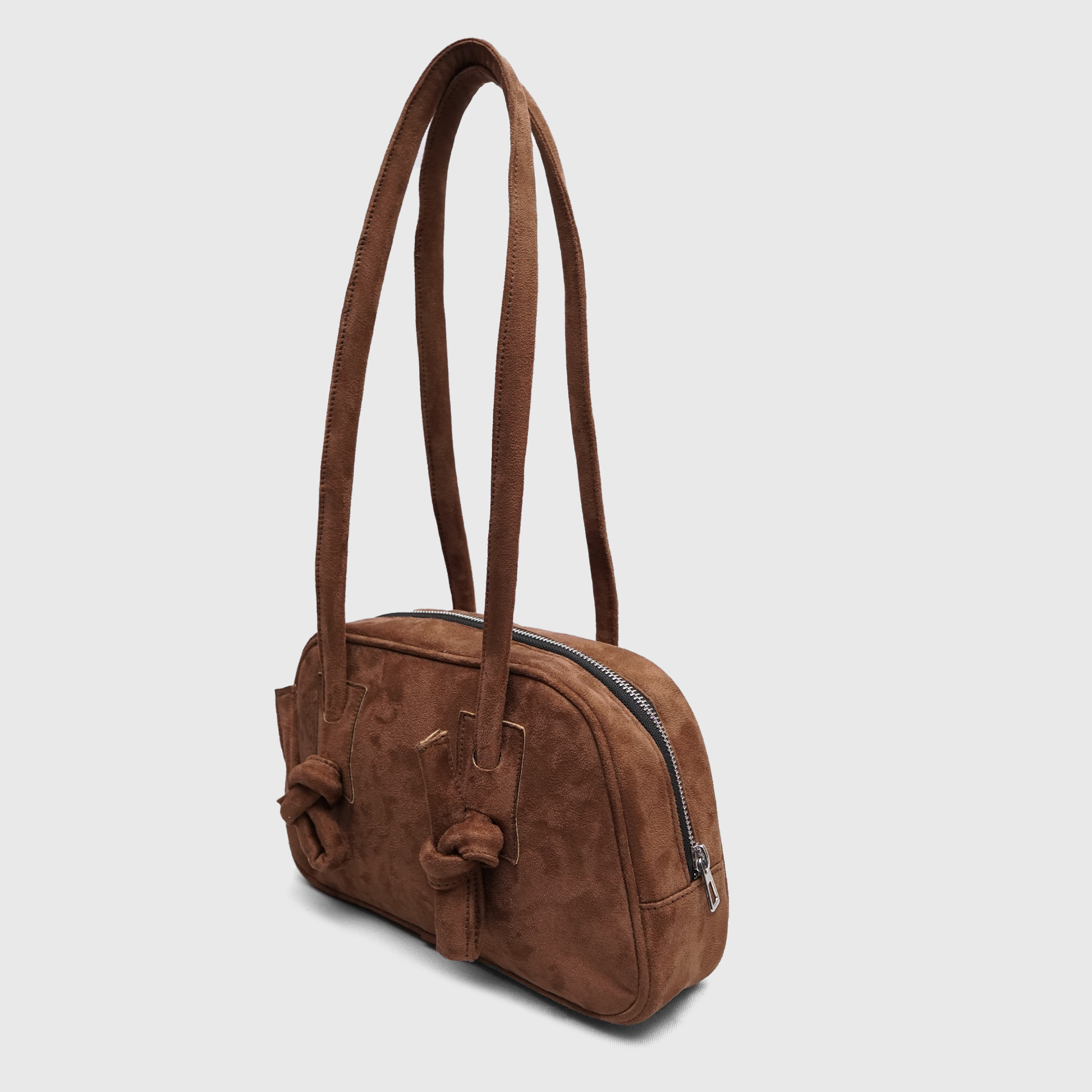 Side profile of brown suede shoulder handbag